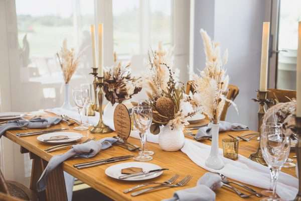 Long table rustic look, small florals with cheesecloth runner and wooden accents.