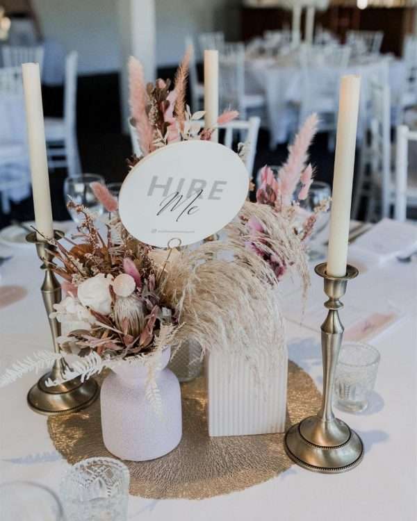 Hire wedding reception flowers and candles. Pink wedding florals. Gold pillar candles.