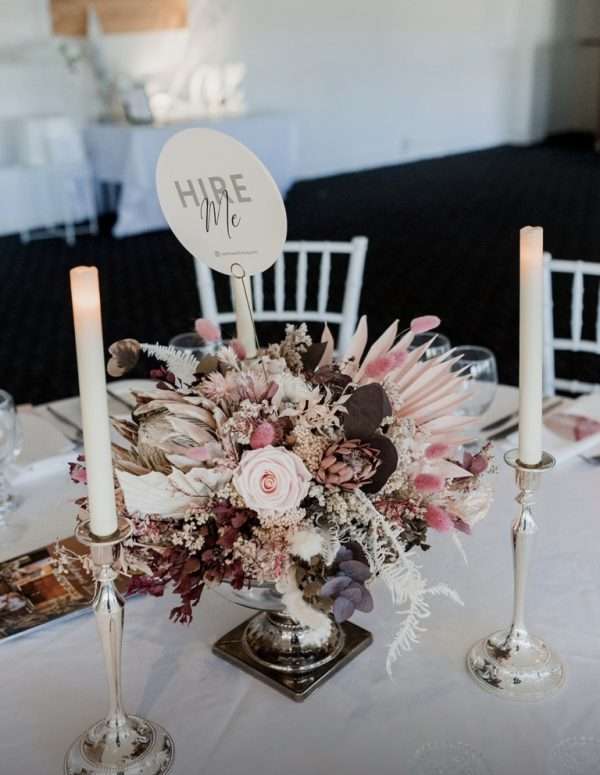 Hire wedding reception flower centrepieces. Pink hues flower centrepiece. Silver wedding reception table candles.