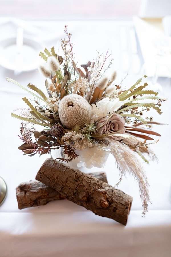 rustic wooden logs with small neutral coloured dried and preserved HIRE posy. bunch. small flower bunch.