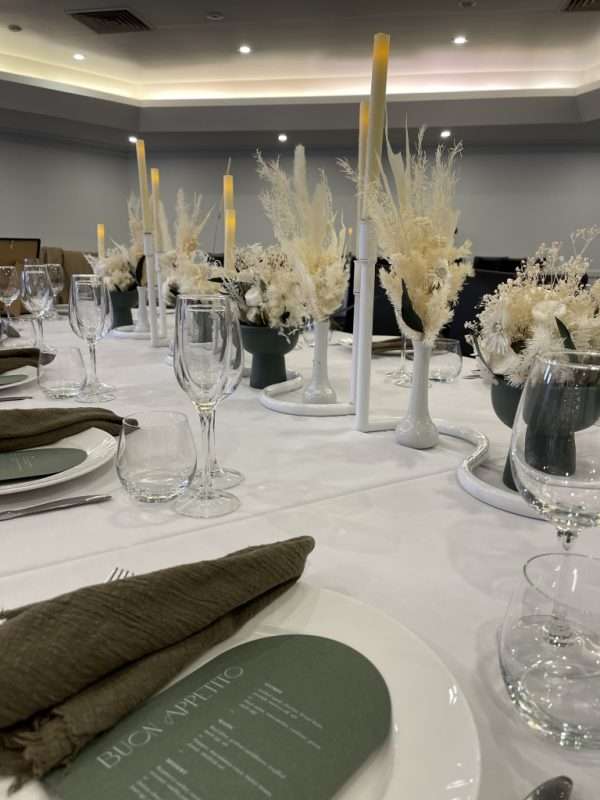 white wedding reception centrepiece. long wedding table flowers. white, green and gold wedding reception table centrepieces. white candlesticks