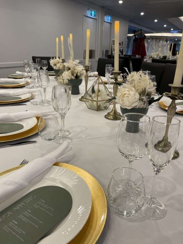 white wedding reception centrepiece. long wedding table flowers. white, green and gold wedding reception table centrepieces. gold candlesticks
